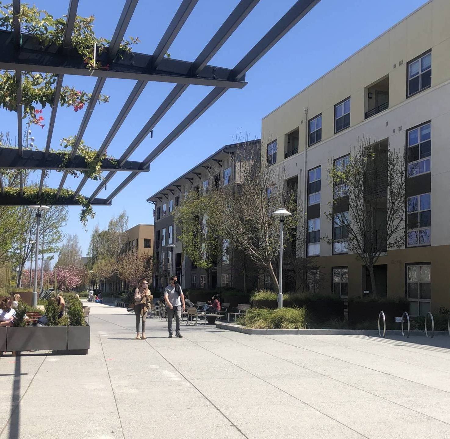 couple-walking-on-plaza-by-apartments