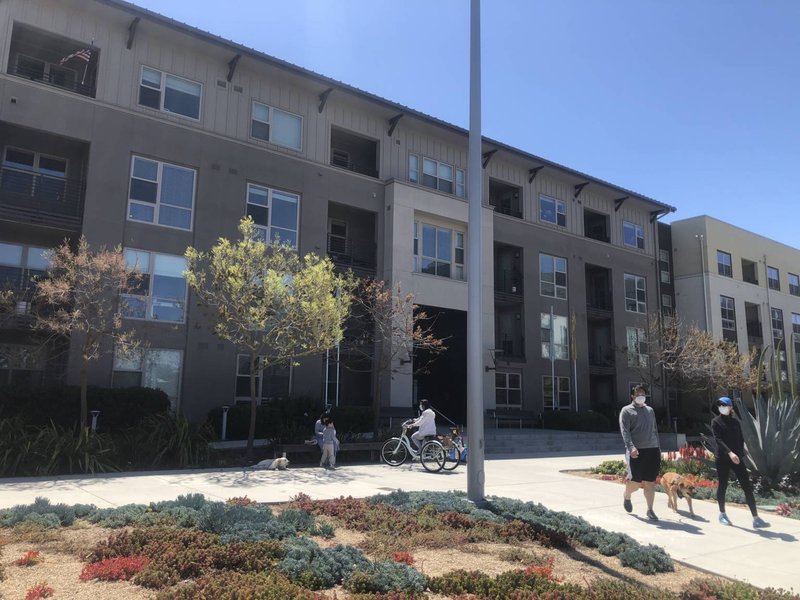 people-in-masks-and-family-in-front-of-large-apt-complex-1536x1152
